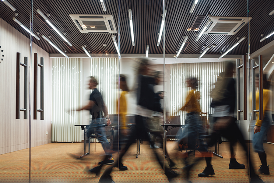 Time lapse image of people walking through an office