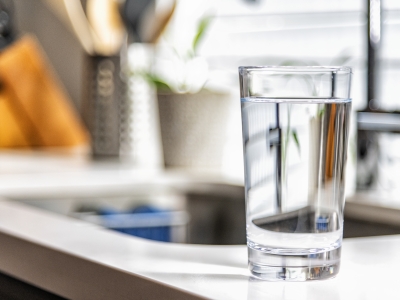 Image of a glass with clear water in it on kitchen bench.