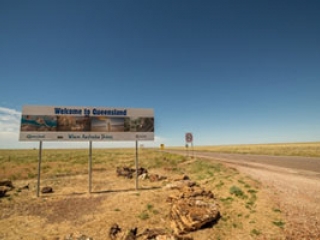 Road sign in outback Queensland displaying 'Welcome to Queensland'