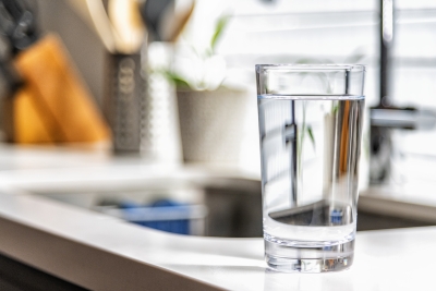 Image of a glass with clear water in it on kitchen bench.